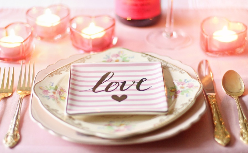 Des assiettes, des couverts et des bougies dans un style romantique
